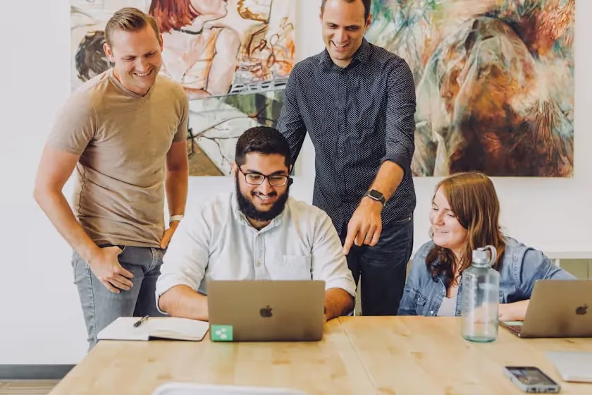 Team gathered around a laptop