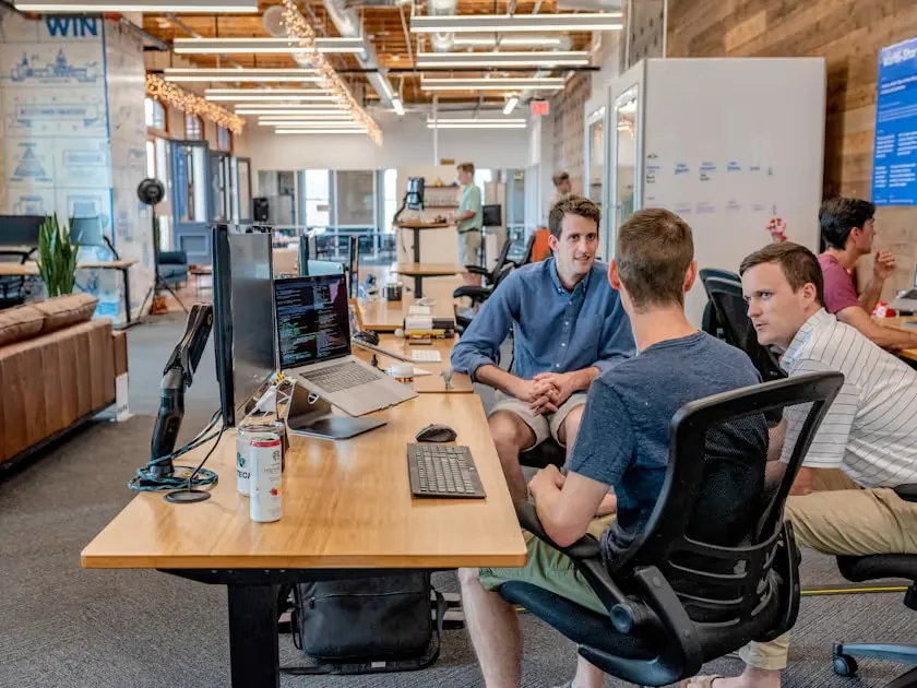 Two colleagues in discussion at dual monitors