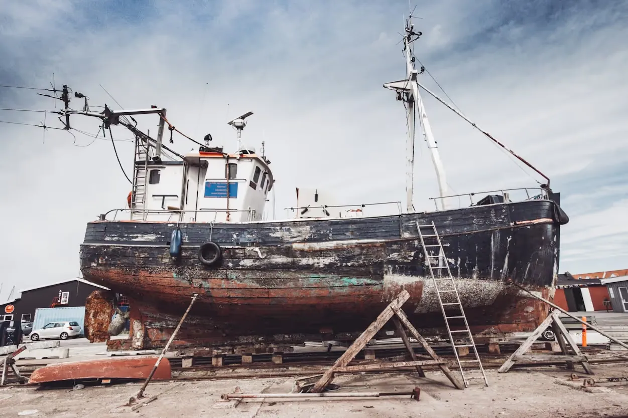 Fishing vessel in dry dock for hull repair and maintenance