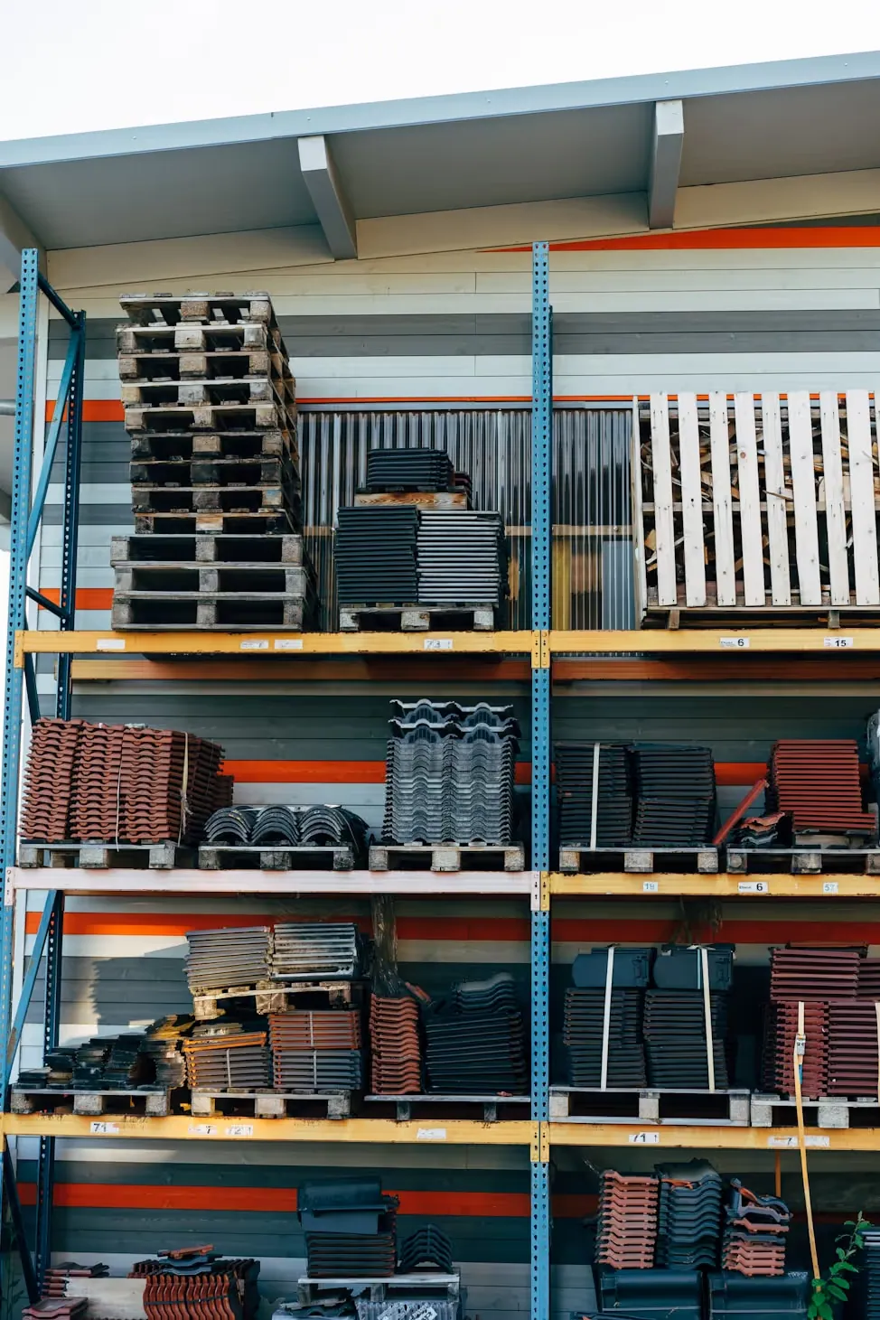 Organised racks of construction materials including roofing tiles
